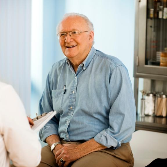 Arzt spricht mit älterem Patienten