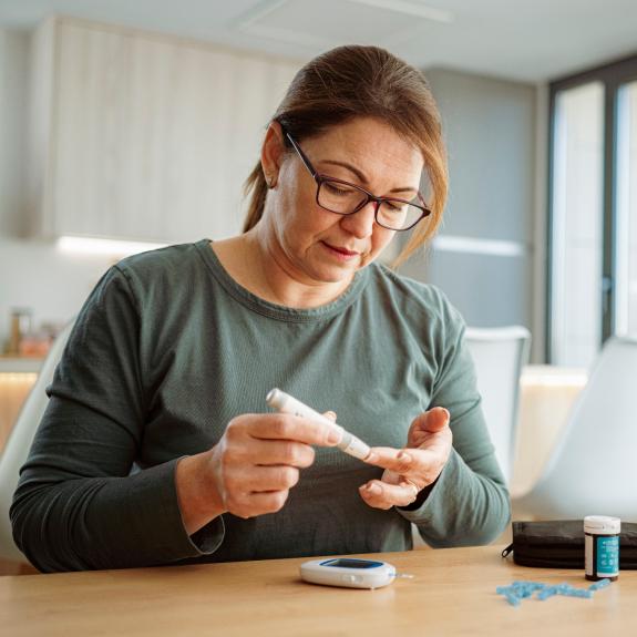 Frau misst ihren Blutzucker