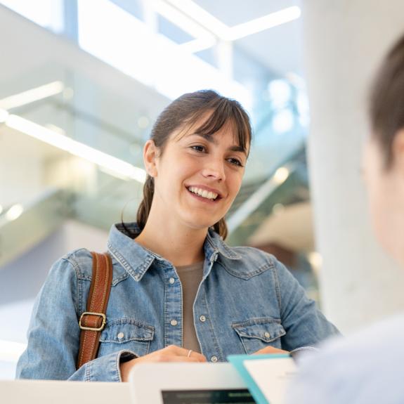 Frau spricht mit MFA am Empfang